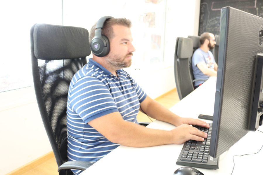 Uomo con cuffie lavora al computer in un ufficio di Tenerife.