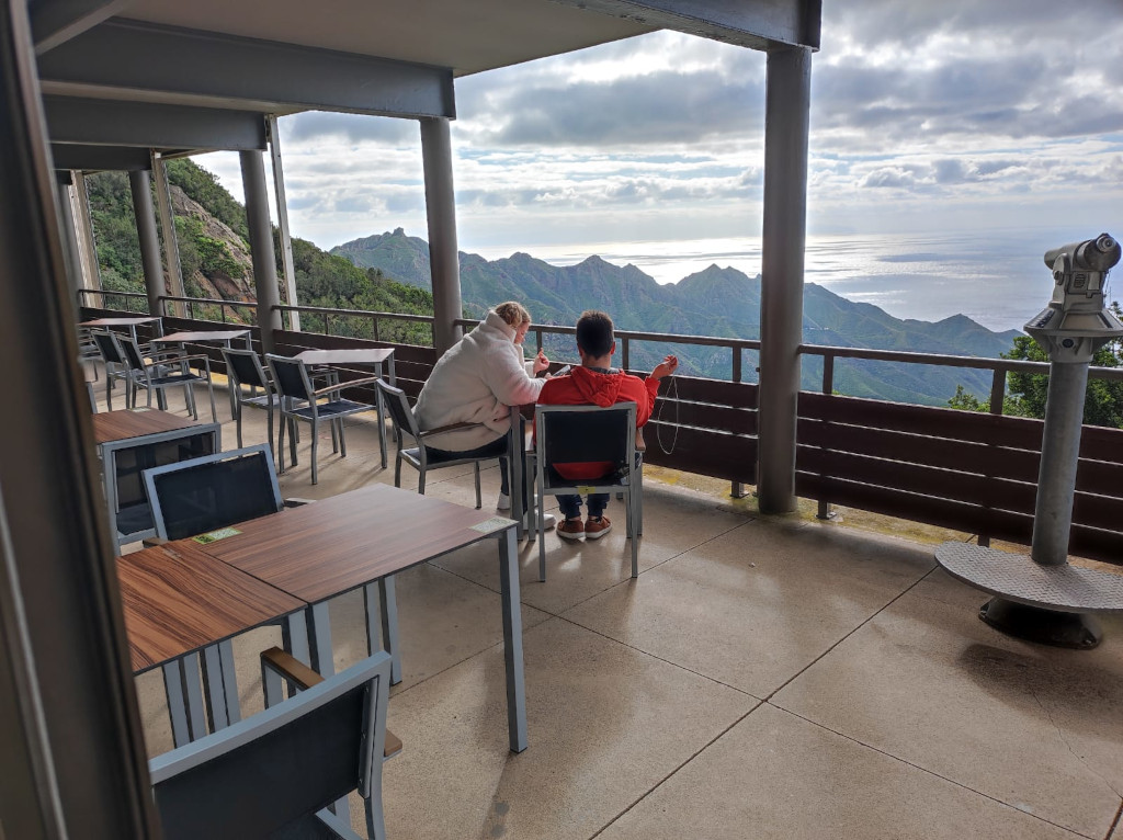 Due persone sedute su una terrazza con vista su monti e mare a Tenerife.