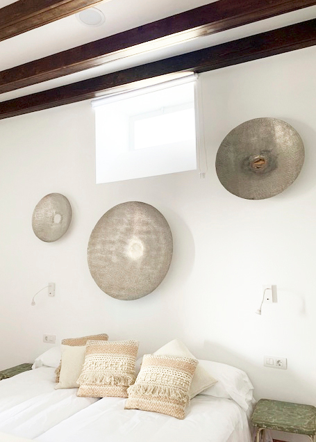 Decorazioni a parete sopra un letto con cuscini in una camera a Tenerife.