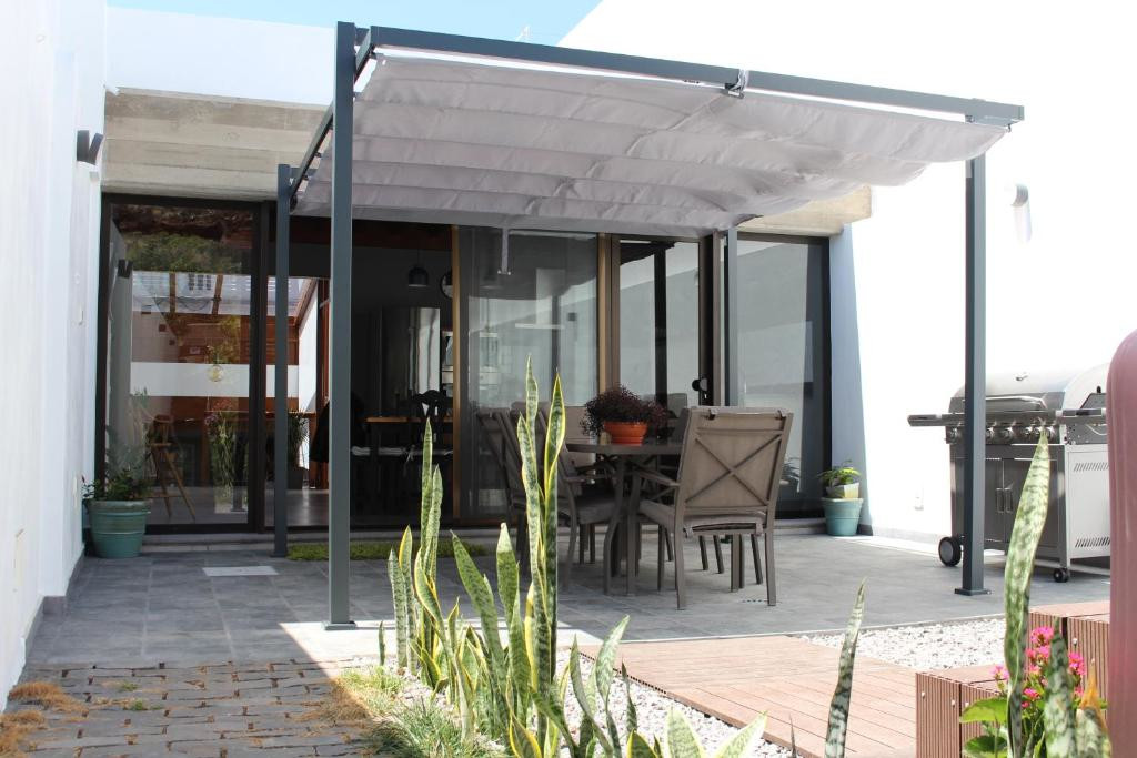 Terraza moderna con mesa y sillas bajo pérgola en Tenerife.