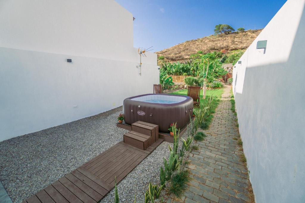 Jacuzzi all'aperto in un cortile circondato da pareti bianche a Tenerife.