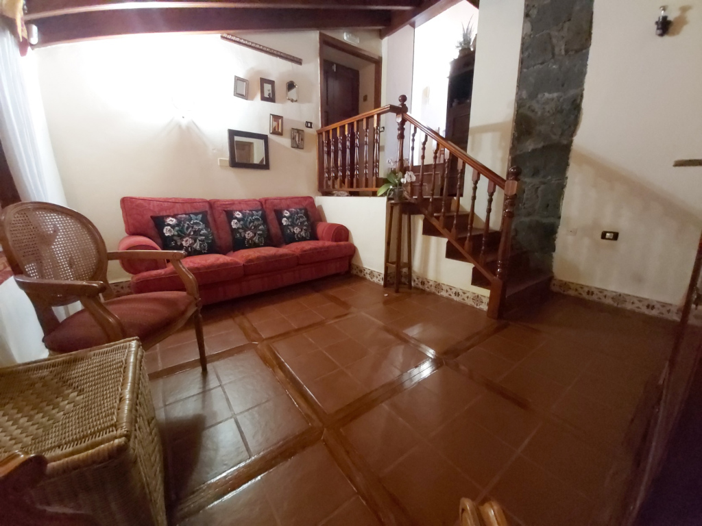 Soggiorno con divano rosso e scala in una casa a Tenerife.