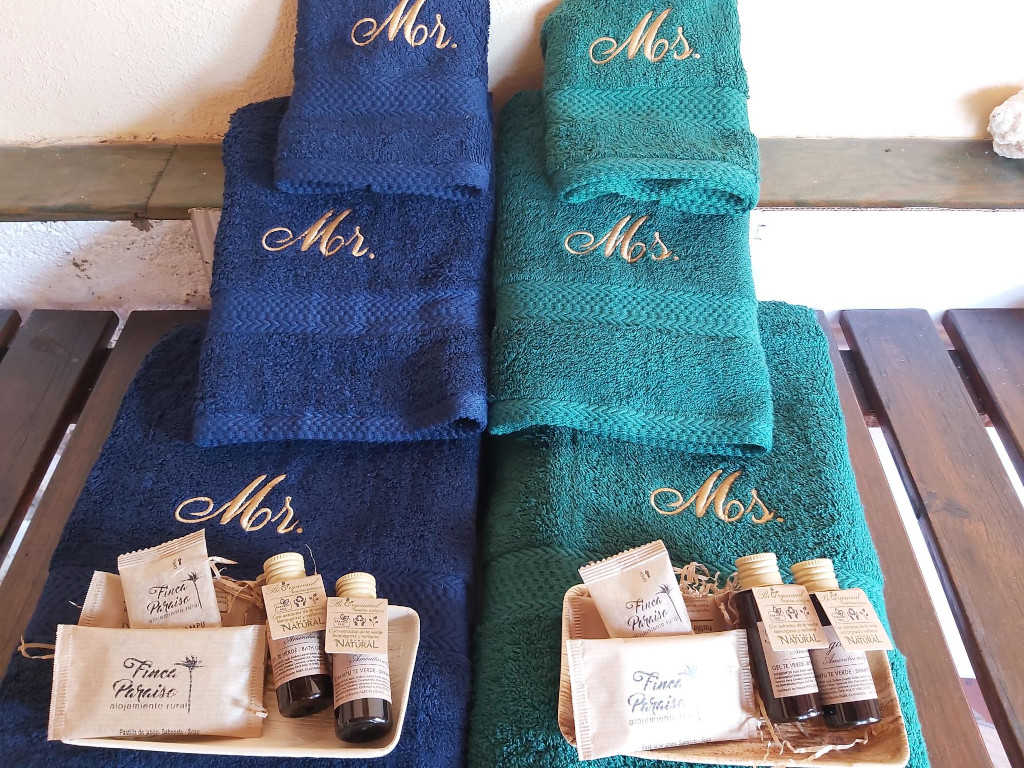 Asciugamani blu e verdi con scritte Mr. e Ms. su un tavolo alla Finca Paraiso, Tenerife.
