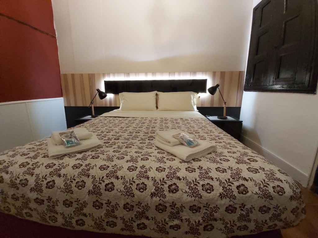 Camera da letto con letto matrimoniale a Tenerife, lampade da lettura e lenzuola floreali.