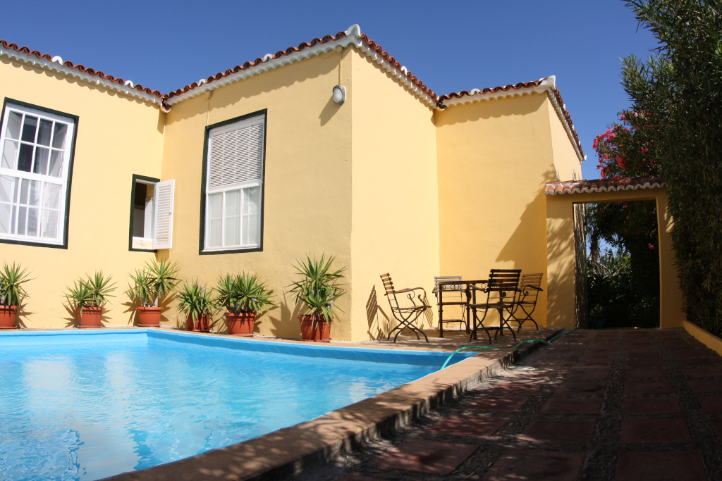 Piscina accanto a una casa gialla con piante e sedie a San Cristóbal de La Laguna, Tenerife.