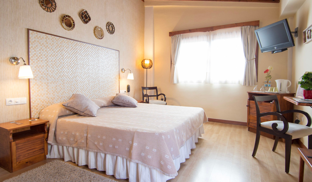 Camera da letto con letto matrimoniale, TV a parete e finestra luminosa a Tenerife.