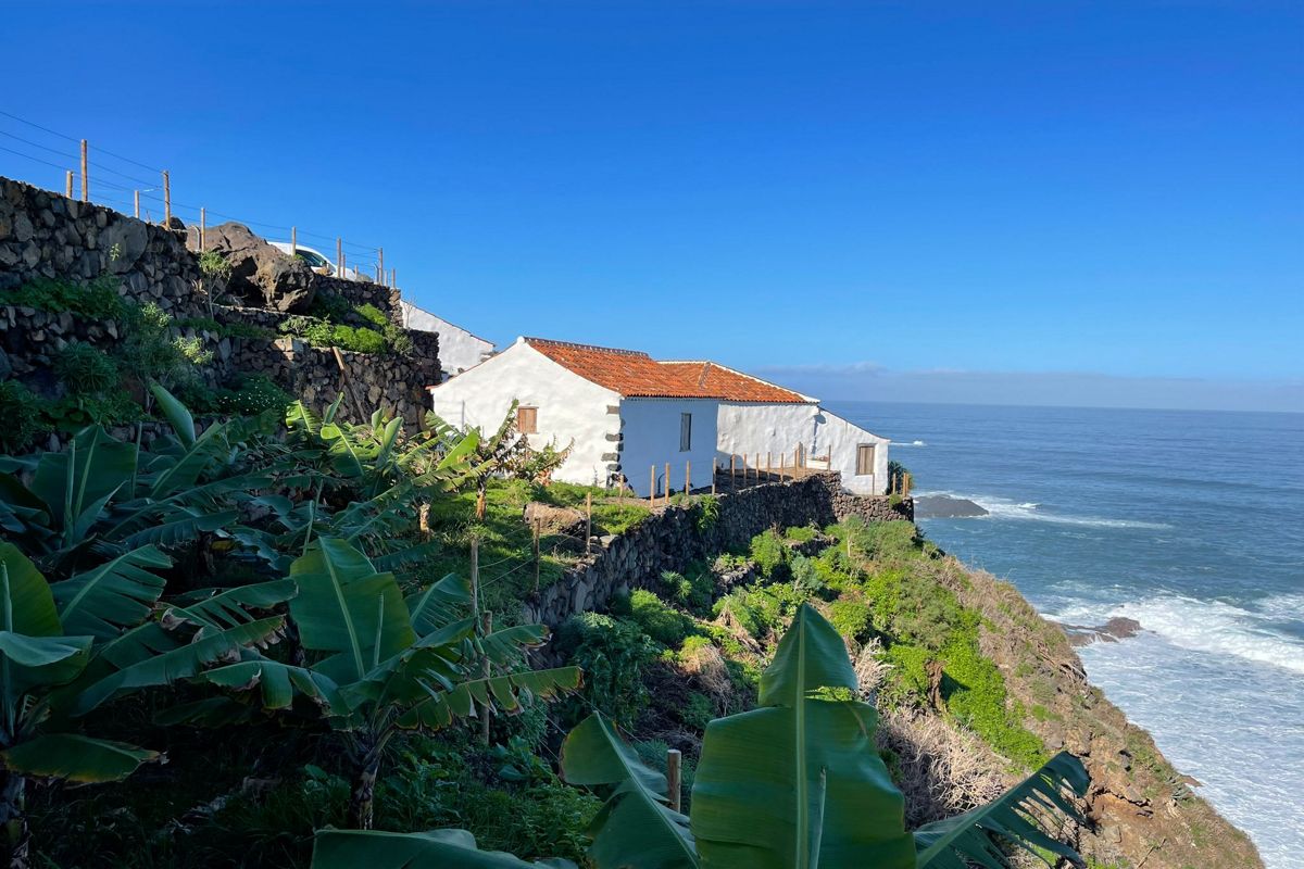 Casa bianca sulla scogliera vicino all’oceano a Tenerife, con piantagioni di banane.