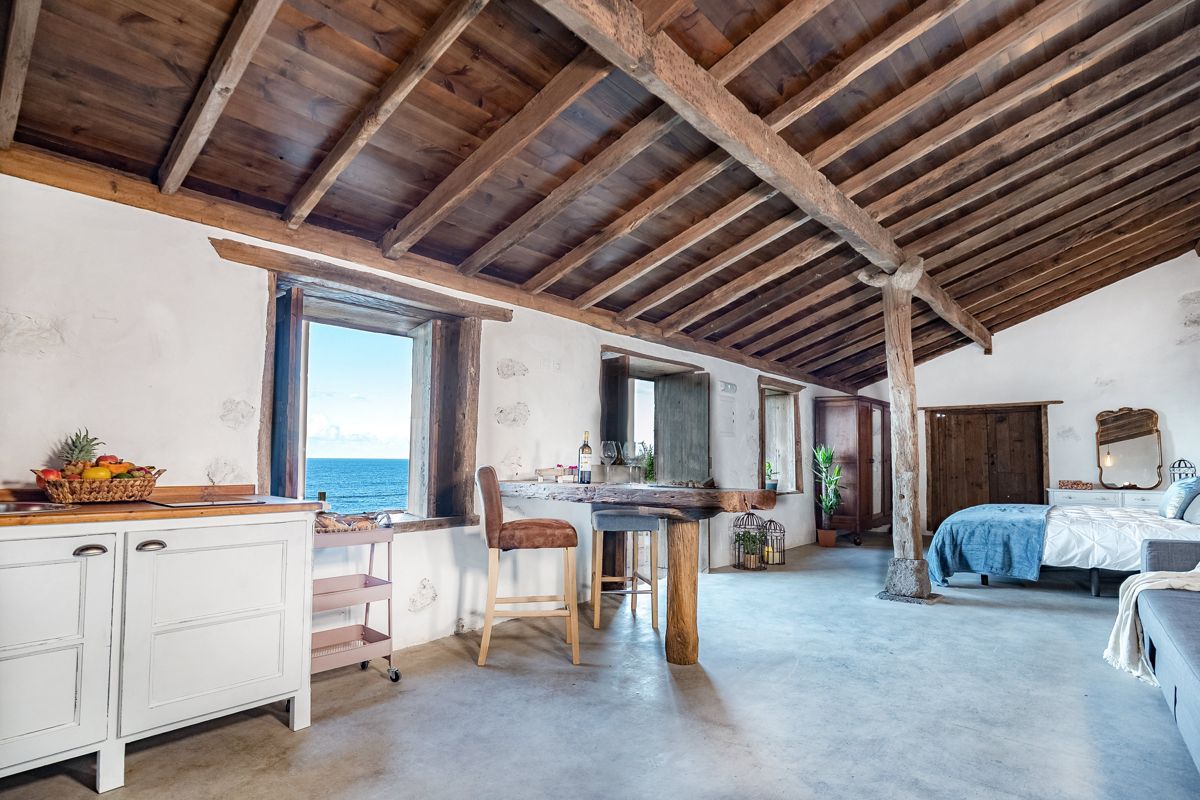Camera spaziosa con letto, tavolo in legno e vista mare a Garachico, Tenerife.