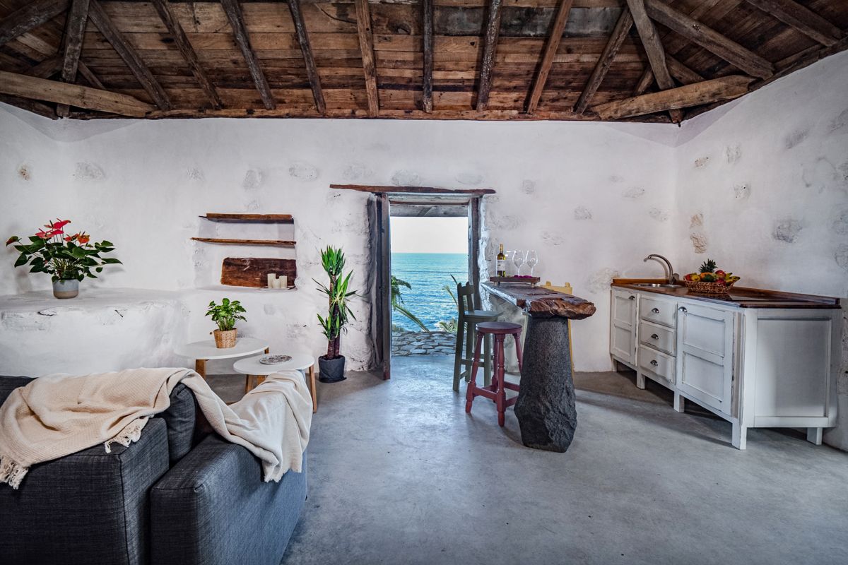 Interno di una casa a Tenerife con vista sull'oceano dalla porta.