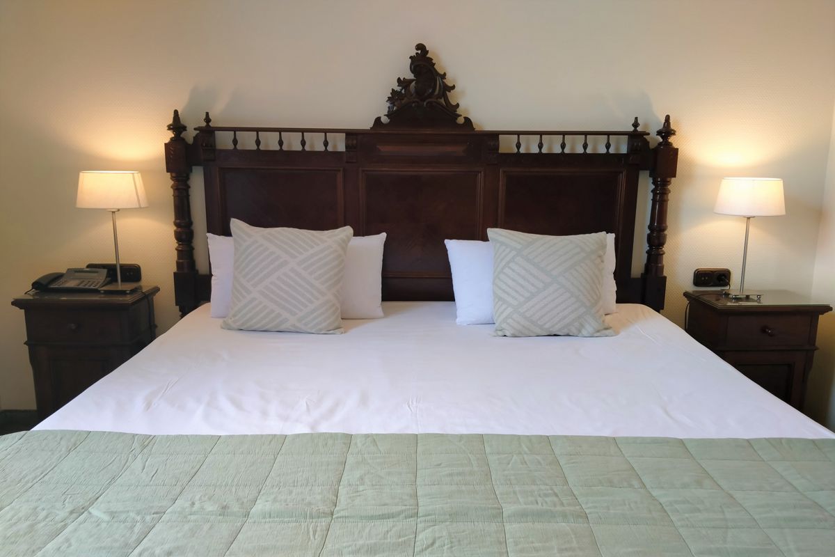 Letto matrimoniale con testiera in legno, lampade ai lati e telefono, Tenerife.