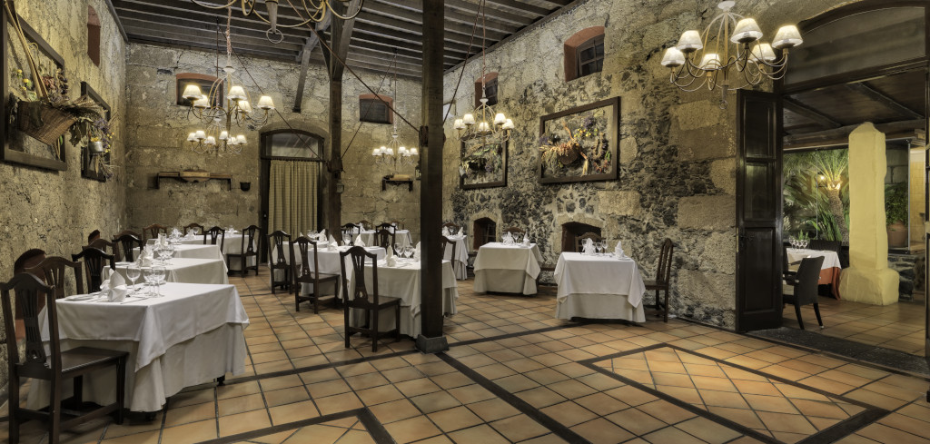 Ristorante elegante a Tenerife con tavoli apparecchiati e decorazioni murali.