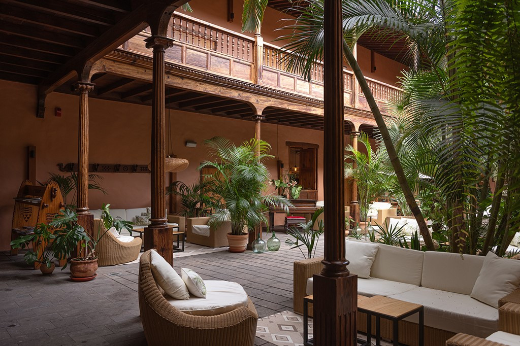 Patio interno con piante e sedute in legno a La Laguna, Tenerife.