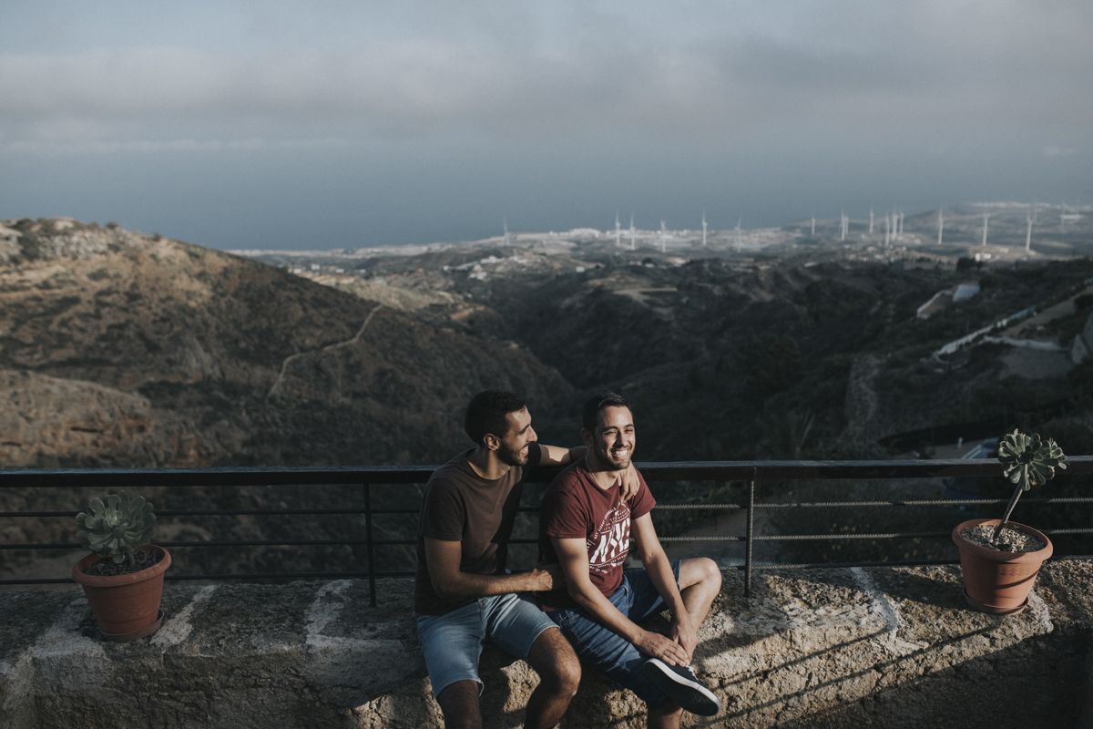 Due persone sedute su un muretto con vista panoramica su Tenerife.