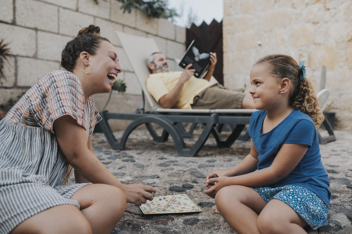 Famiglia gioca a un gioco da tavolo nel patio a Tenerife.
