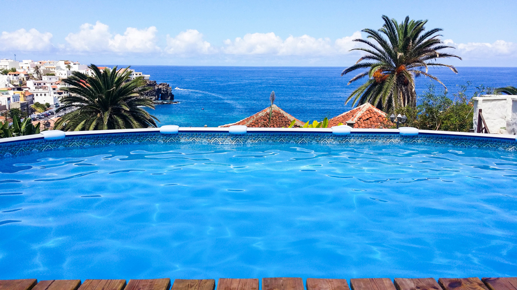 Piscina con vista sull'oceano e palme a Tenerife.