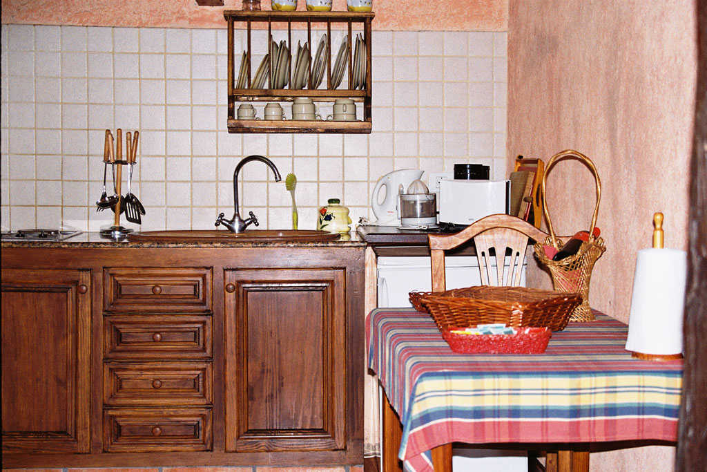 Cucina rustica con tavolo apparecchiato, cestino e elettrodomestici a Tenerife.