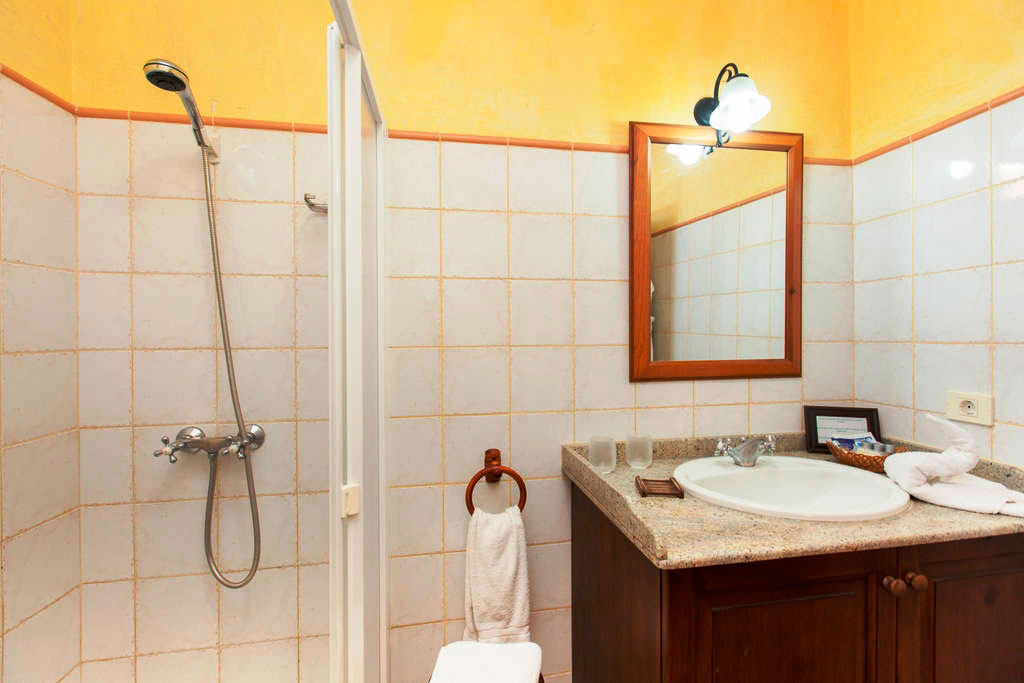 Bagno con doccia e specchio in un hotel a Tenerife.