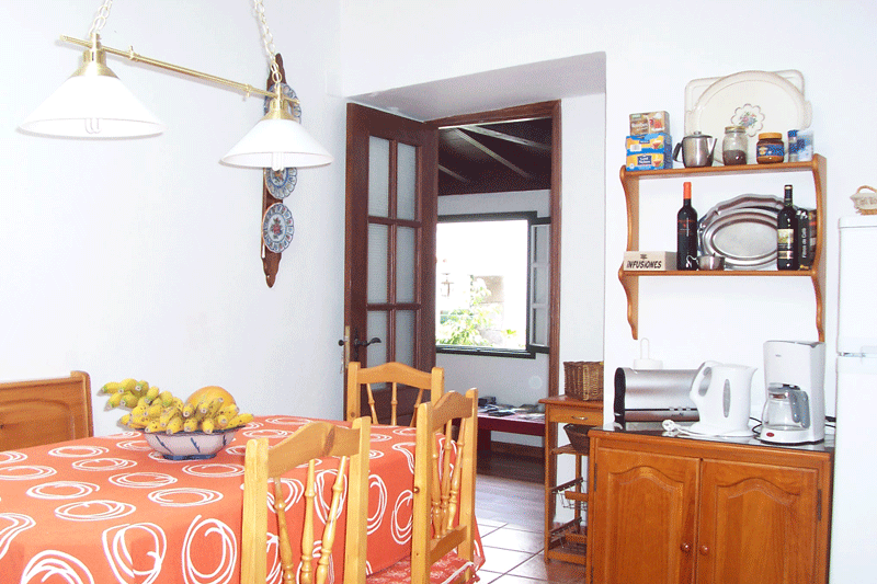 Sala da pranzo con tavolo arancione, sedie e mensole in cucina a Tenerife.