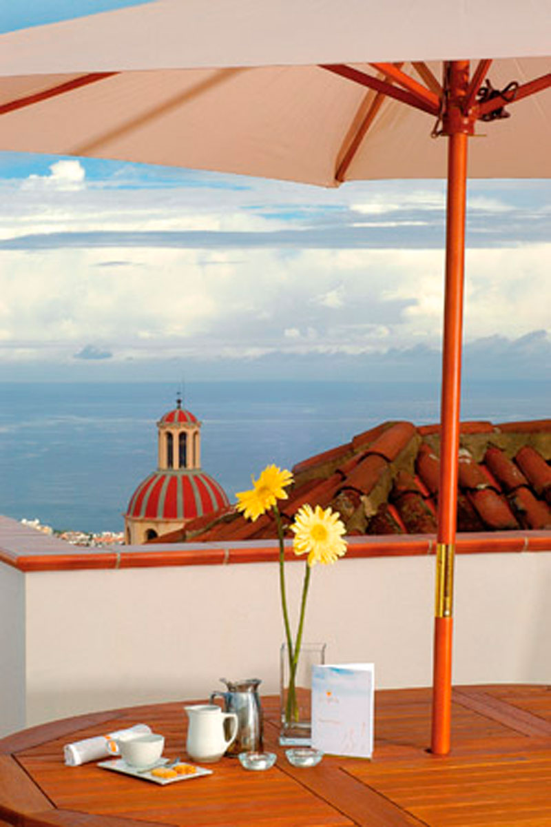 Tavolo con caffè e fiori sotto ombrellone, vista mare a Tenerife.