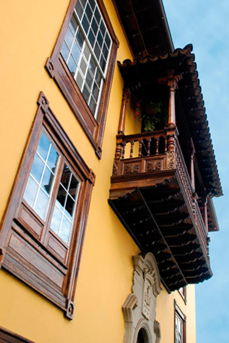 Balcone in legno su edificio giallo a La Orotava, Tenerife.