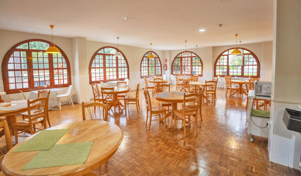 Sala da pranzo con tavoli rotondi e sedie in legno a Tenerife.