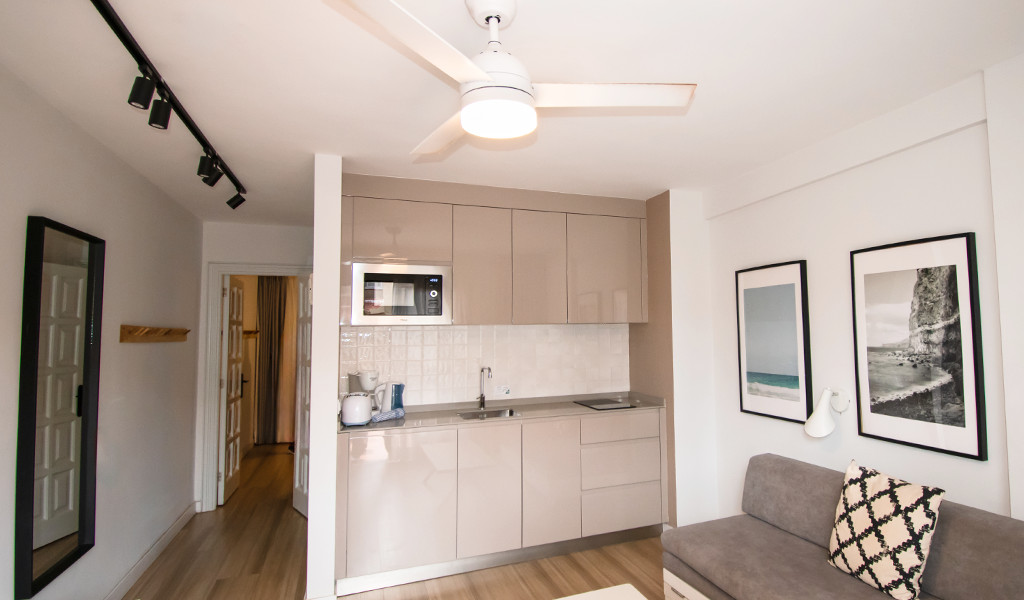 Cucina moderna con microonde e divano in appartamento a Tenerife.