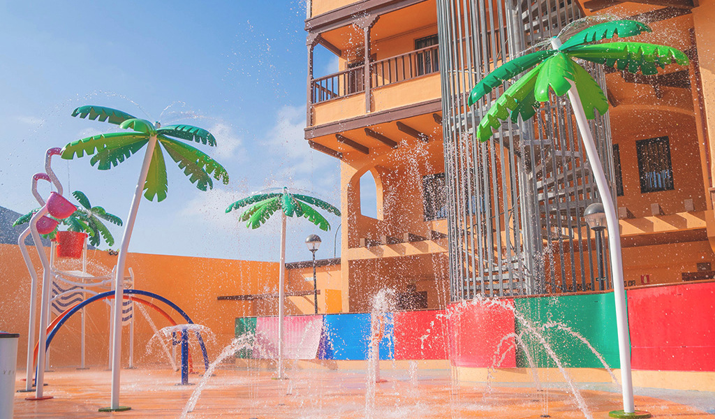 parco giochi acquatico a Tenerife con palme e fontane colorate.