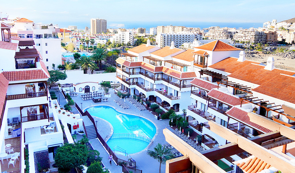 Vista su edifici e piscina in un complesso residenziale a Los Cristianos, Tenerife.