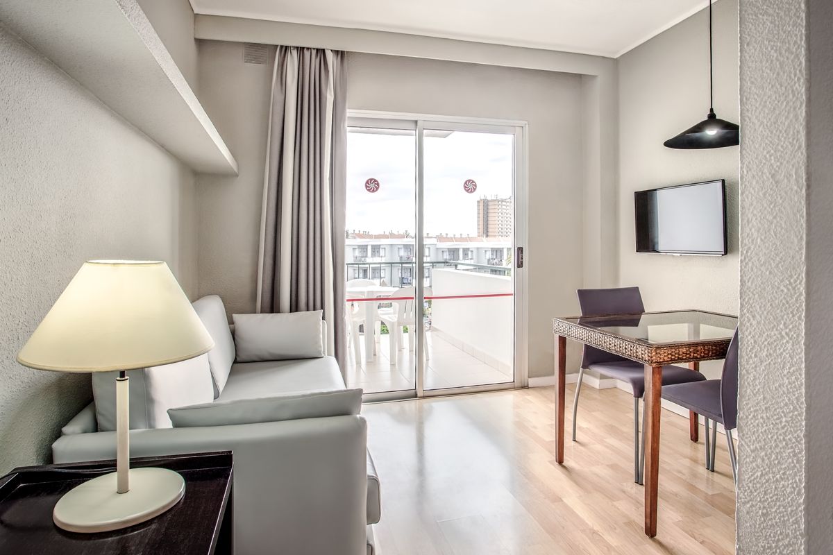 Soggiorno moderno con divano, lampada, tavolo da pranzo e balcone a Tenerife.