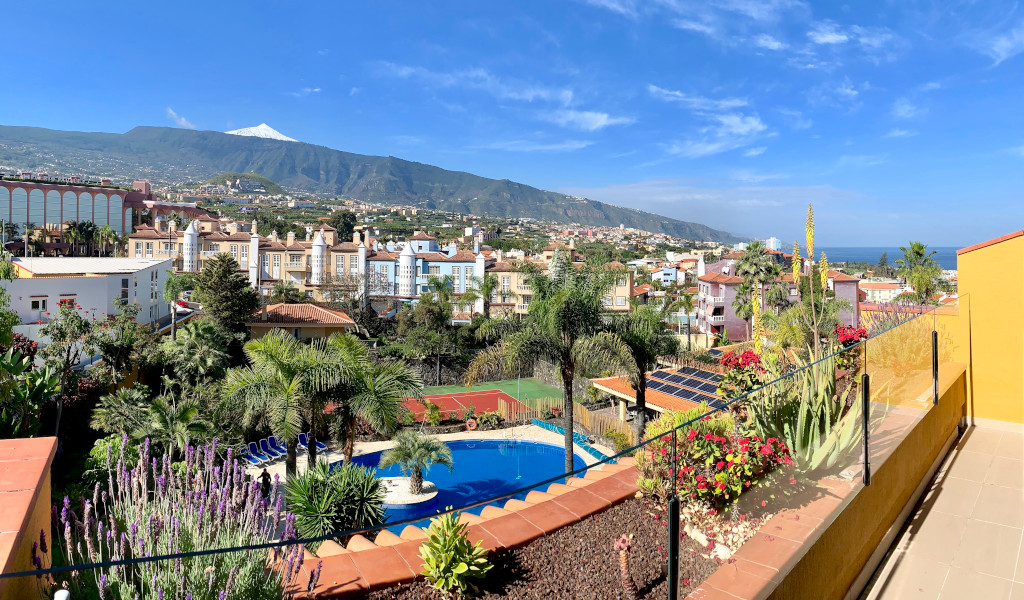 Vista di Puerto de la Cruz con Teide sullo sfondo e piscina centrale.