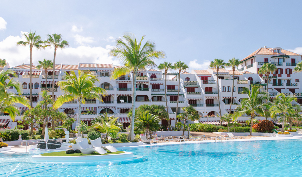 Edificio bianco con piscina e palme a Costa Adeje, Tenerife.