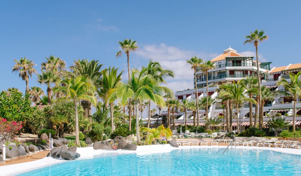 Piscina e palme con hotel sullo sfondo a Tenerife.