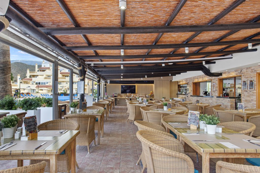 Ristorante all'aperto con tavoli in legno e sedie in vimini a Tenerife.