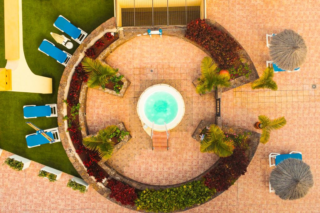 Vista dall'alto di una piscina circondata da lettini e palme a Tenerife.