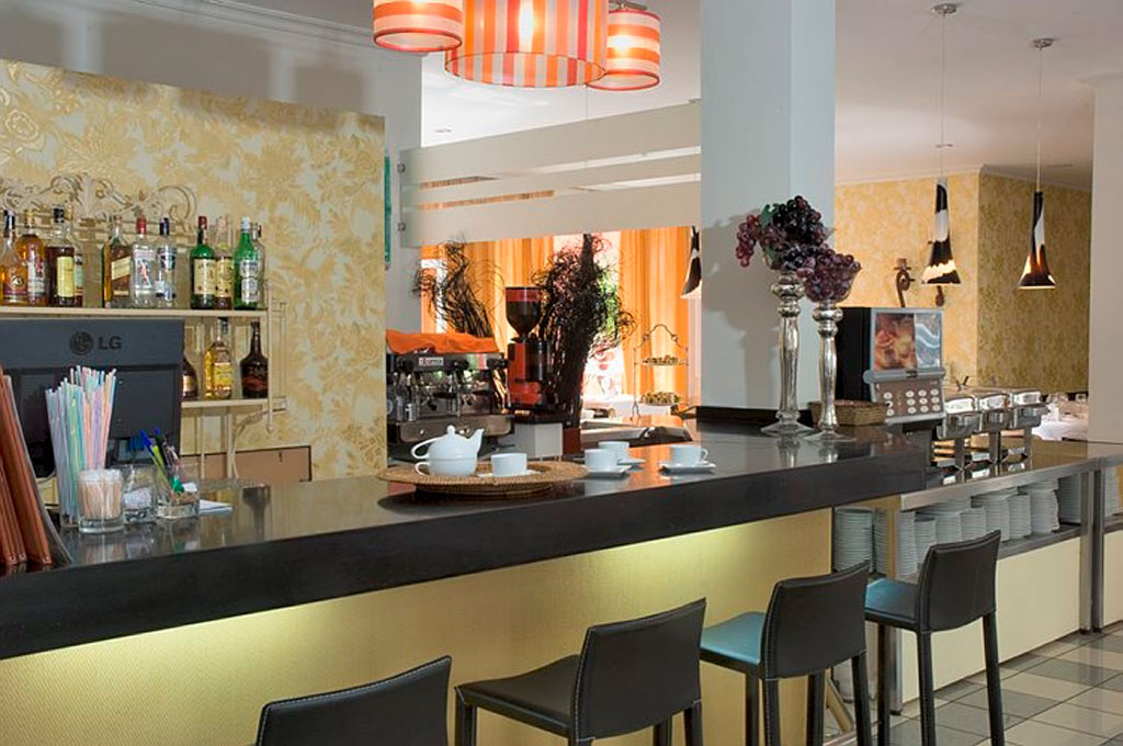 Bar di un ristorante con tavolini e bottiglie, situato a Tenerife.