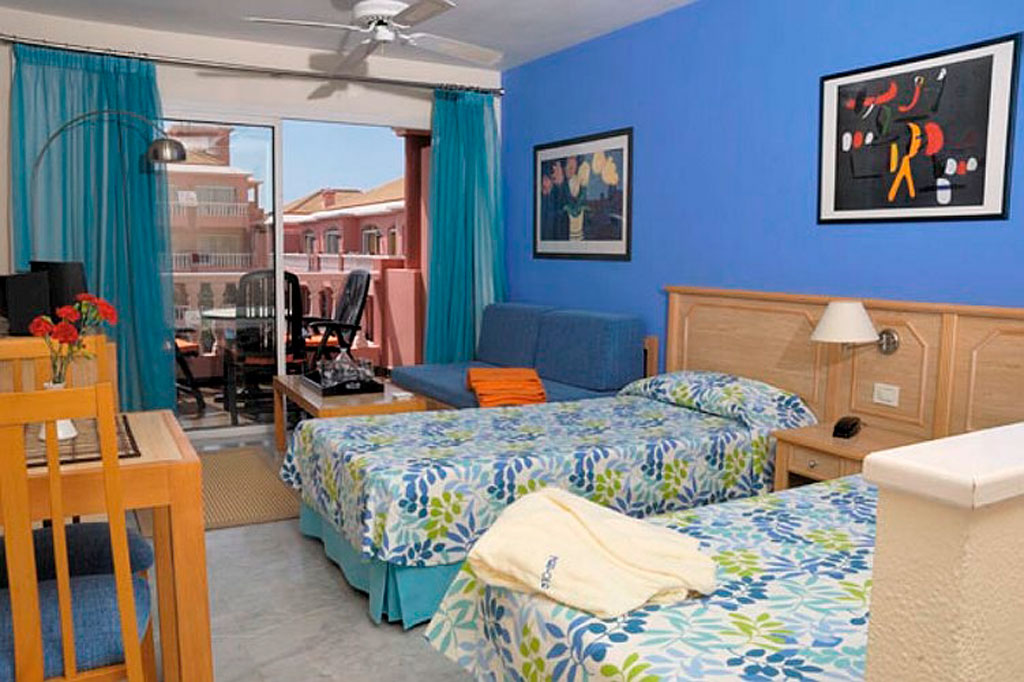 Camera da letto con due letti singoli, terrazza e vista su edifici a Tenerife.