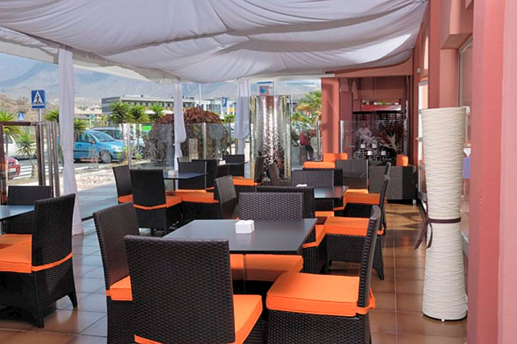 Sala pranzo esterna con tavoli e sedie arancioni a Tenerife.