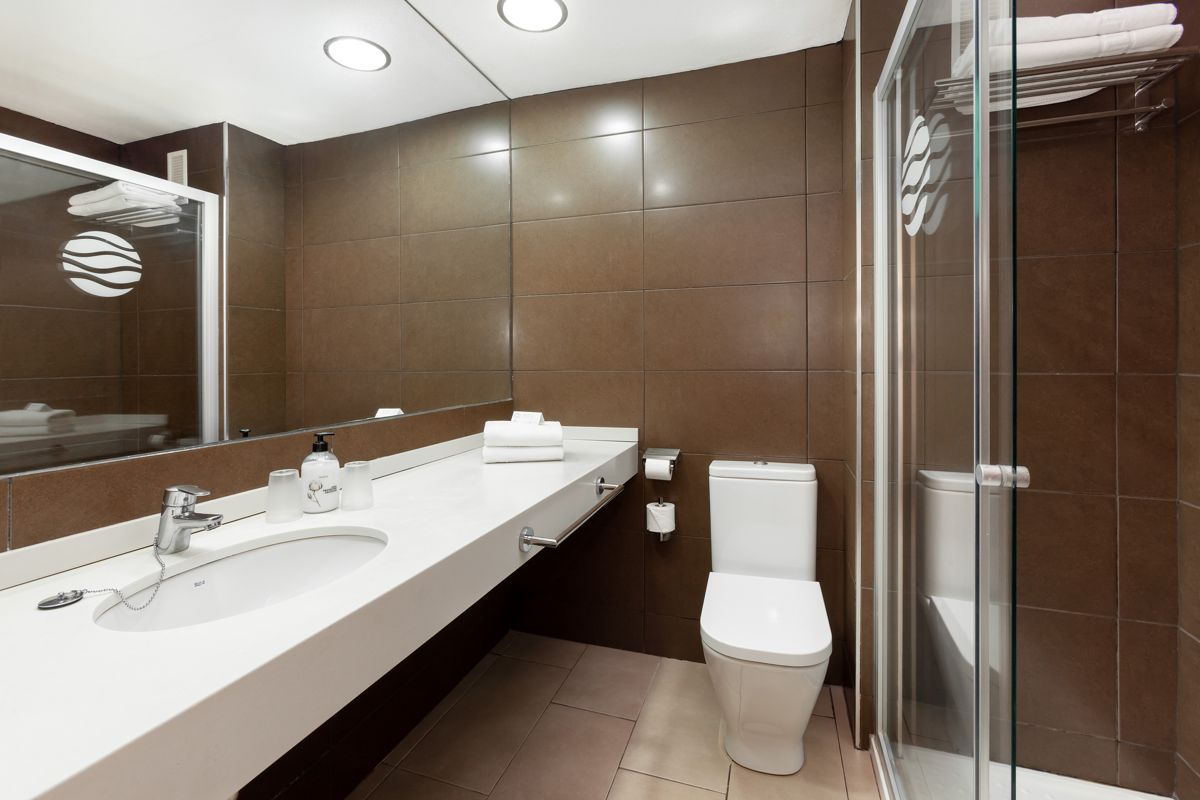 Bagno moderno con lavabo, specchio, WC e doccia in hotel a Tenerife.