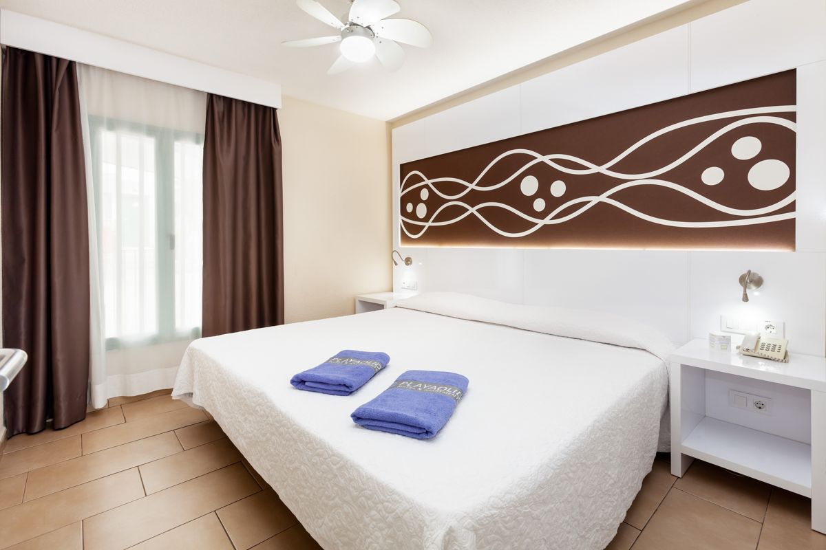 Camera da letto moderna con letto matrimoniale e asciugamani PlayaOlid a Tenerife.