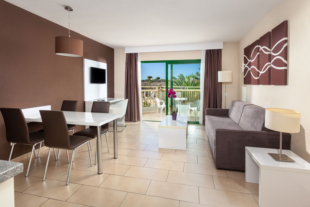 Soggiorno moderno con tavolo da pranzo e divano, terrazza con piante a Tenerife.