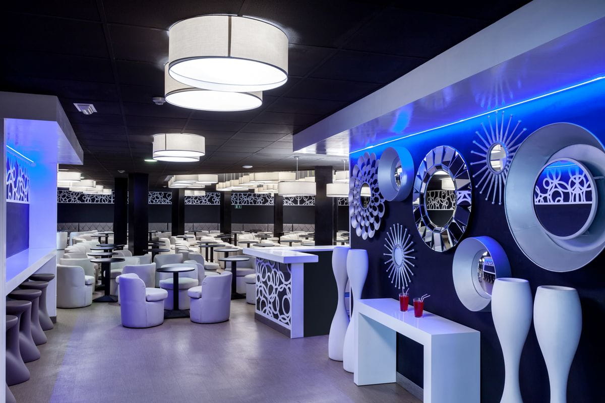 Sala moderna con sedie bianche e parete decorata con specchi a Santa Cruz de Tenerife.