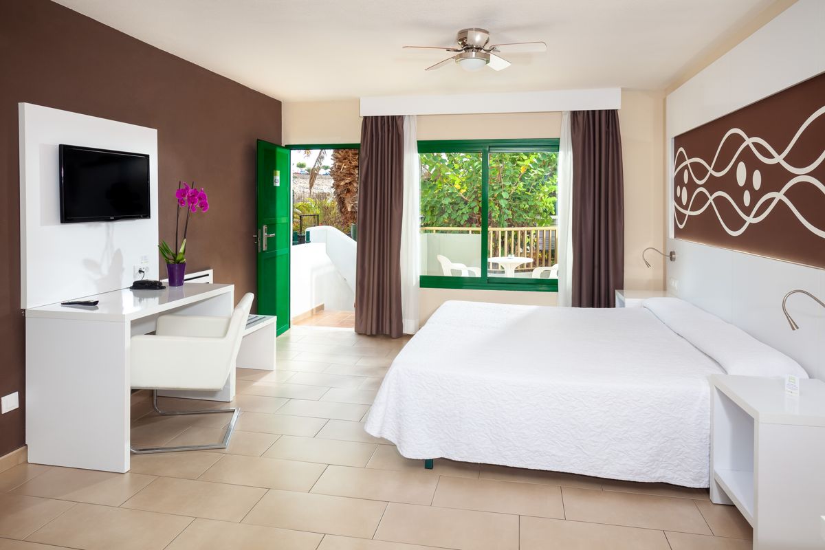 Camera d'albergo con letto matrimoniale, TV, scrivania e balcone a Tenerife.