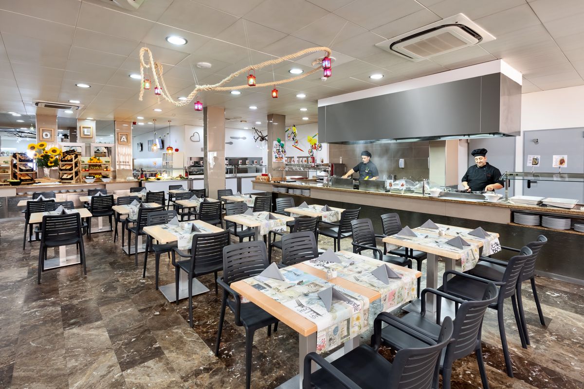 Sala ristorante con tavoli coperti e chef al lavoro a Tenerife.