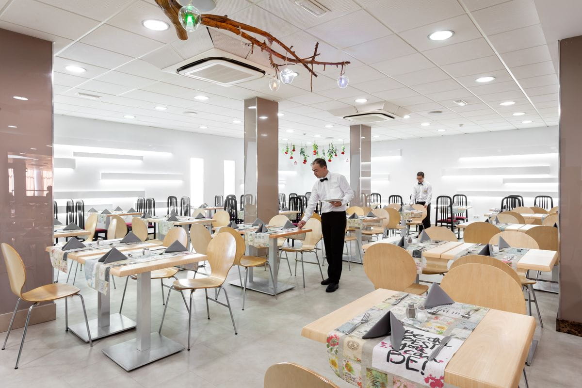 Interno di un ristorante a Tenerife con camerieri in sala apparecchiata.