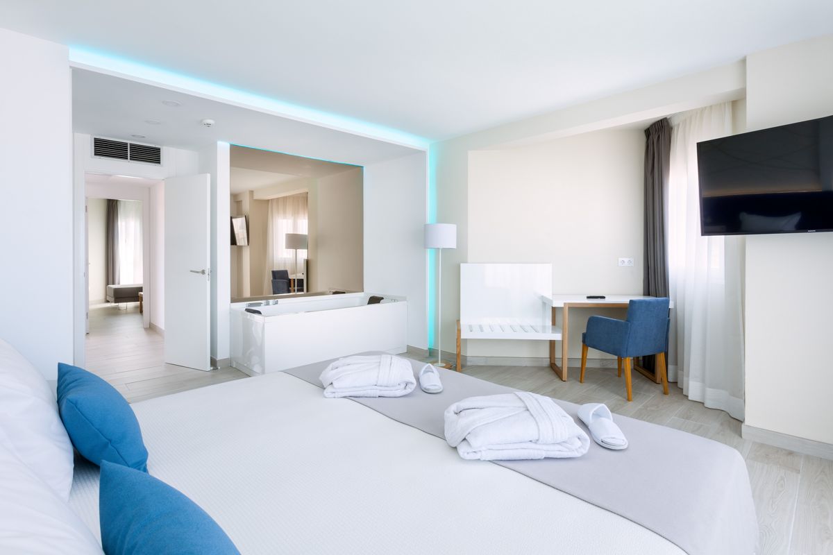 Camera d'albergo luminosa con letto matrimoniale, scrivania e TV a Tenerife.
