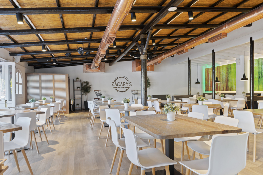 Ristorante Zacary's con tavoli in legno e sedie bianche a Tenerife.