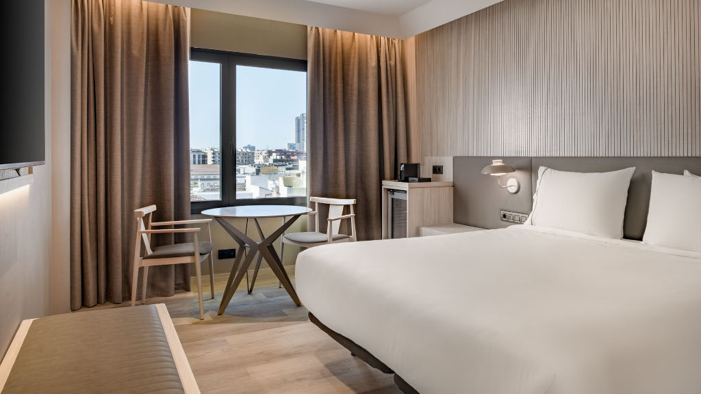 Camera d'albergo a Tenerife con letto matrimoniale, tavolo e vista sulla città.