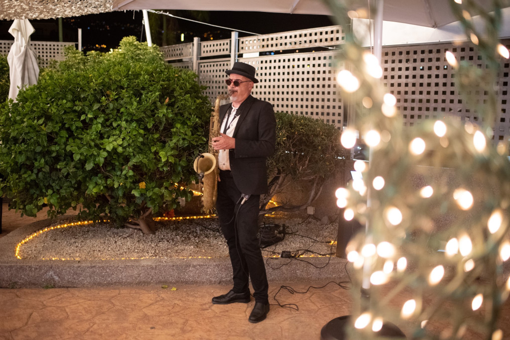 Sassofonista suona di sera in un giardino a Tenerife.