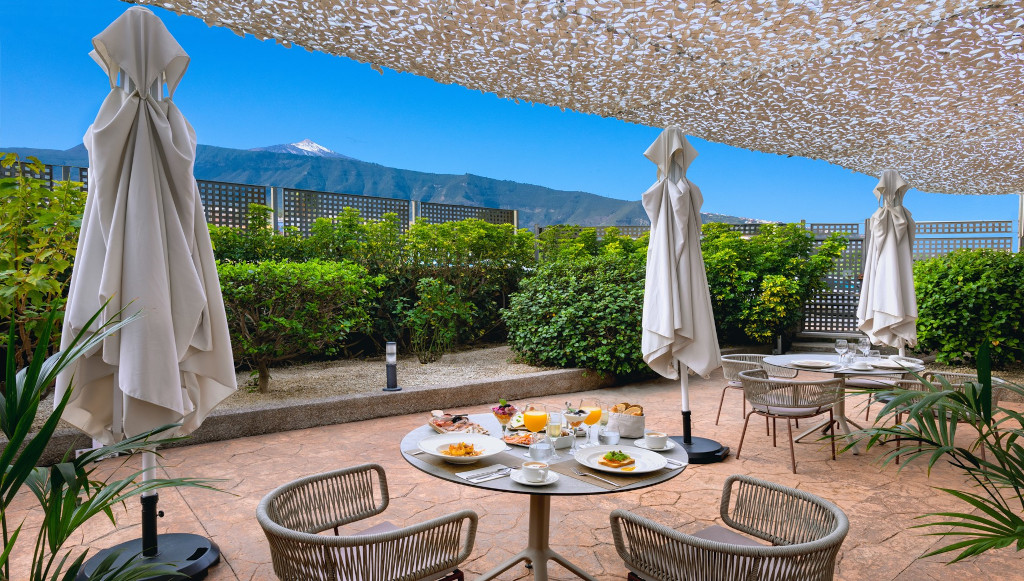Terrazza con tavoli apparecchiati, ombrelloni e vista sul Monte Teide, Puerto de la Cruz.