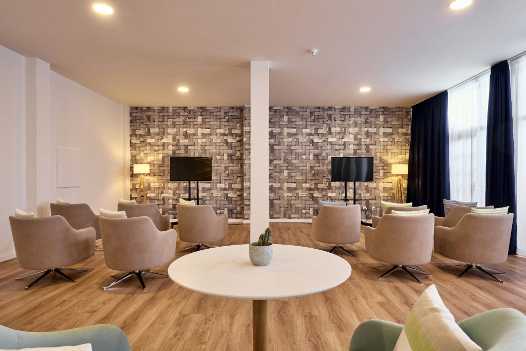 Sala conferenze moderna con sedie beige e schermi, a Tenerife.